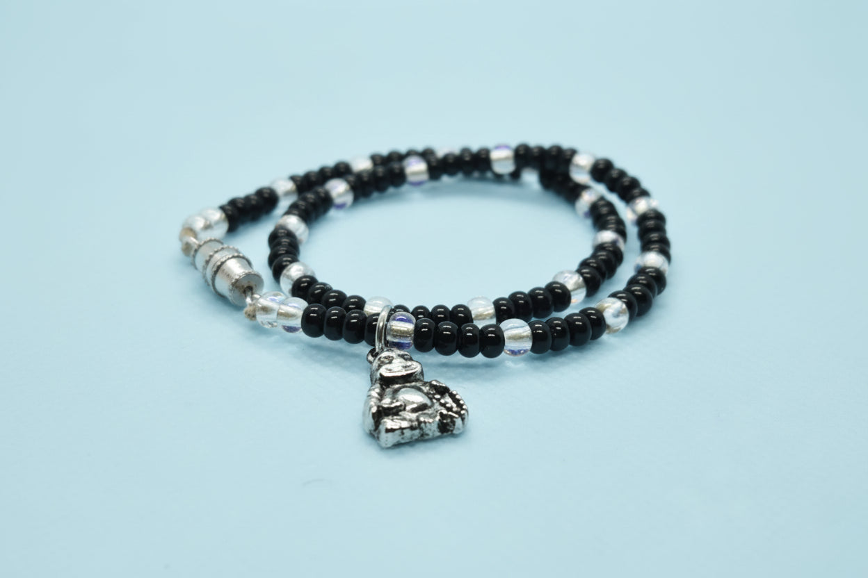 Black and silver beaded bracelet with a heart charm on a white background