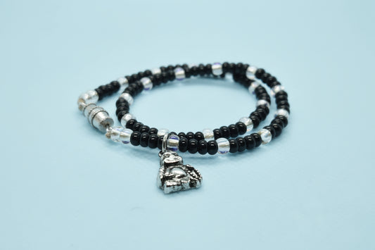 Black and silver beaded bracelet with a heart charm on a white background