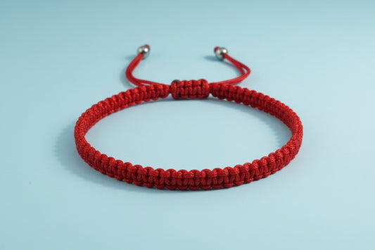 Red braided bracelet on a white background